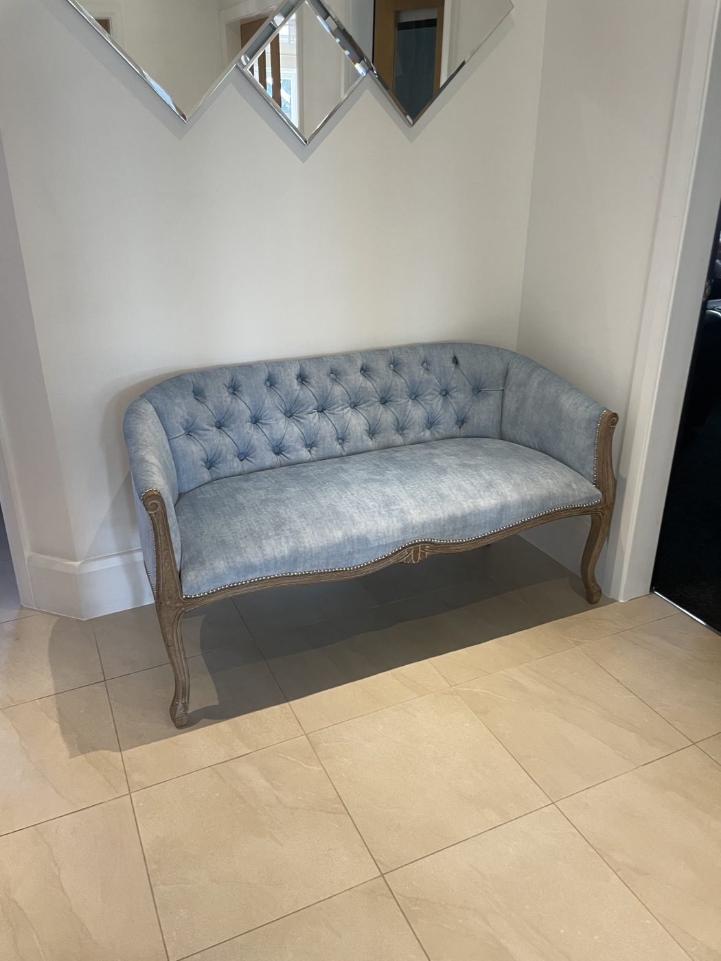 Deep-buttoned settee in pale blue chenille with carved legs