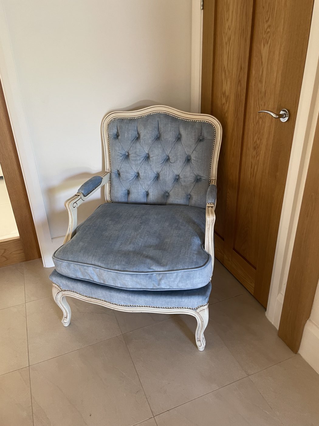 French-style carved armchair re-upholstered in buttoned blue chenille