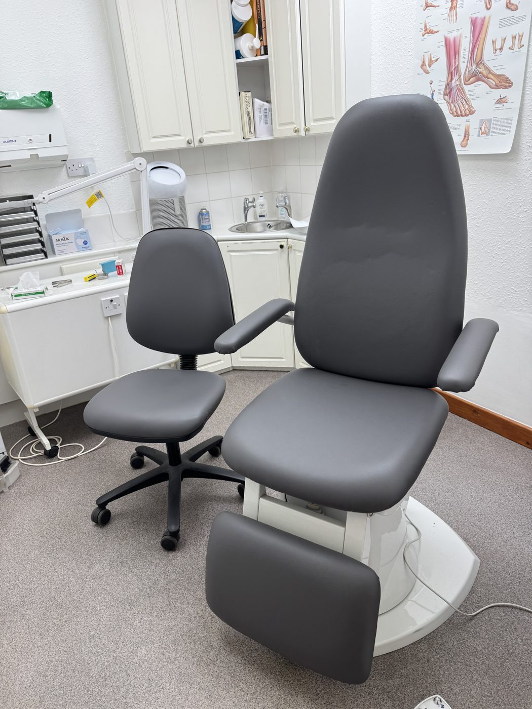 Medical clinic treatment chair re-upholstered in compliant grey vinyl