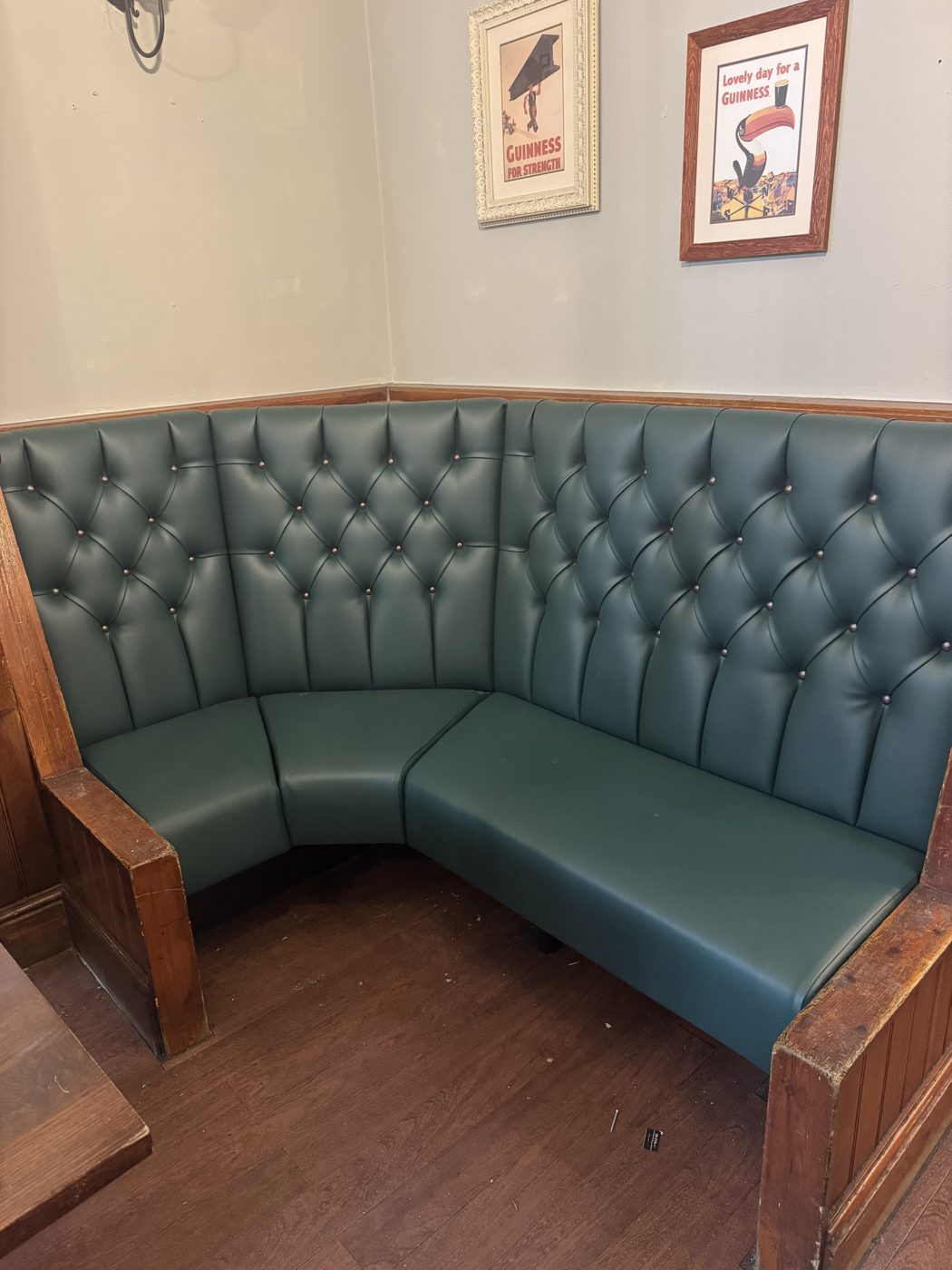 Green buttoned chesterfield corner booth re-upholstered in a traditional pub